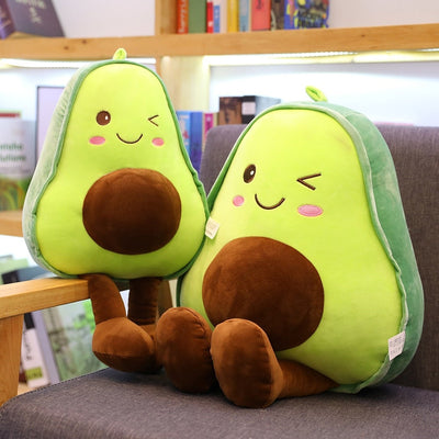 two avocado pillow plushies on a chair winking and rosy red cheeks