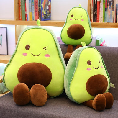 Three stuffed avovado pillows on a chair with legs dangling